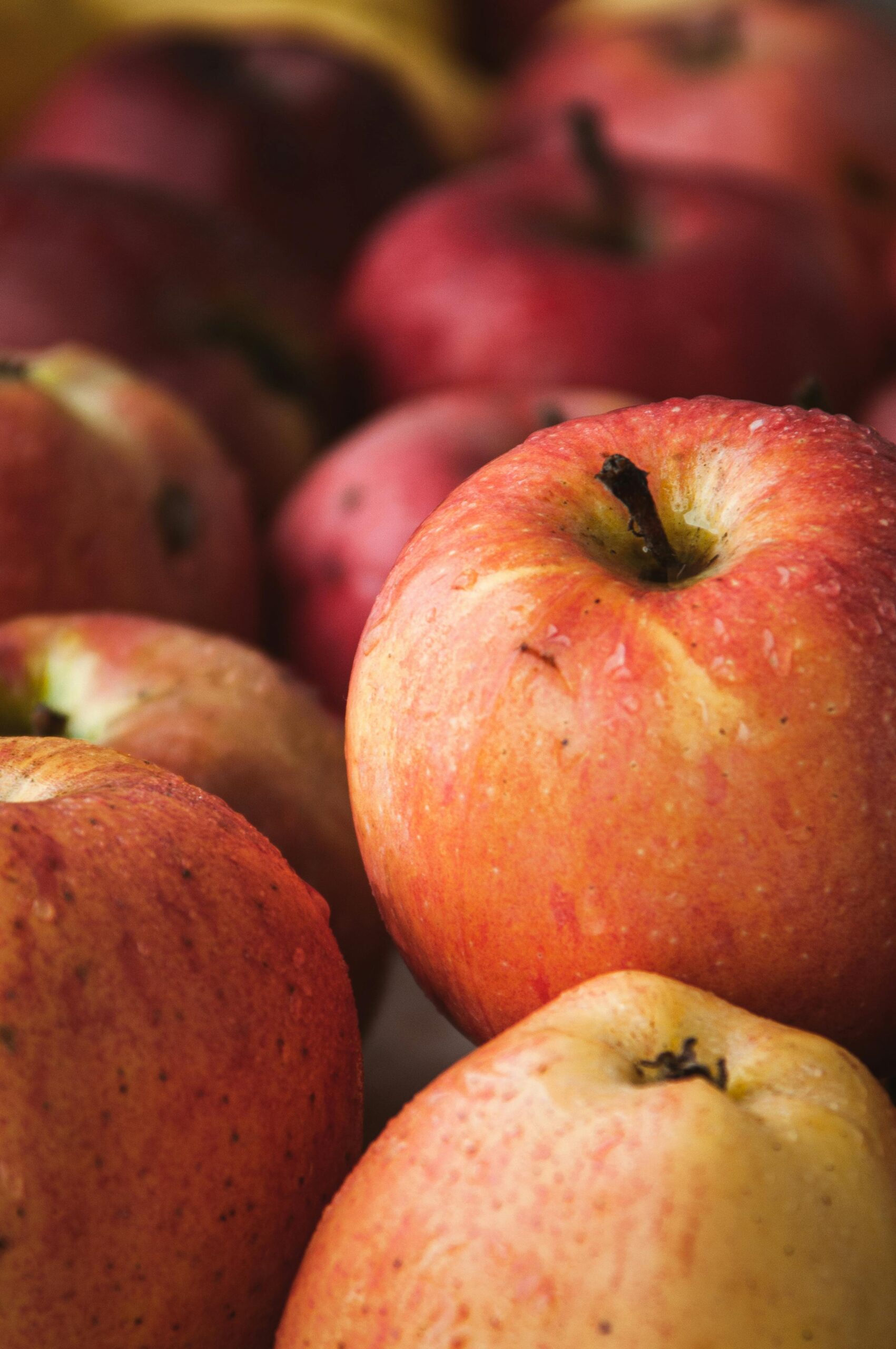 Vibrant fresh red apples stacked closely, showcasing their natural texture and healthy appeal.
